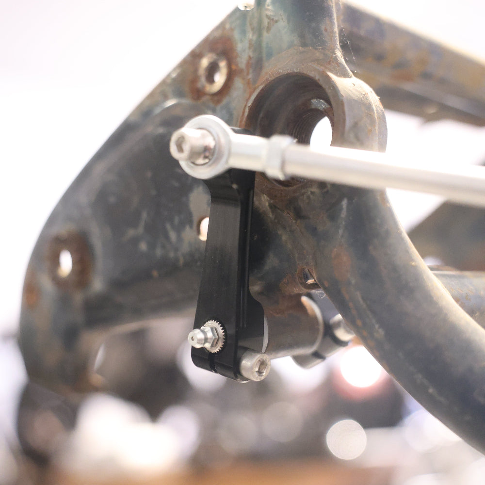 Close-up of a mechanical component on a vehicle, possibly a motorcycle or atv, with blurred background.