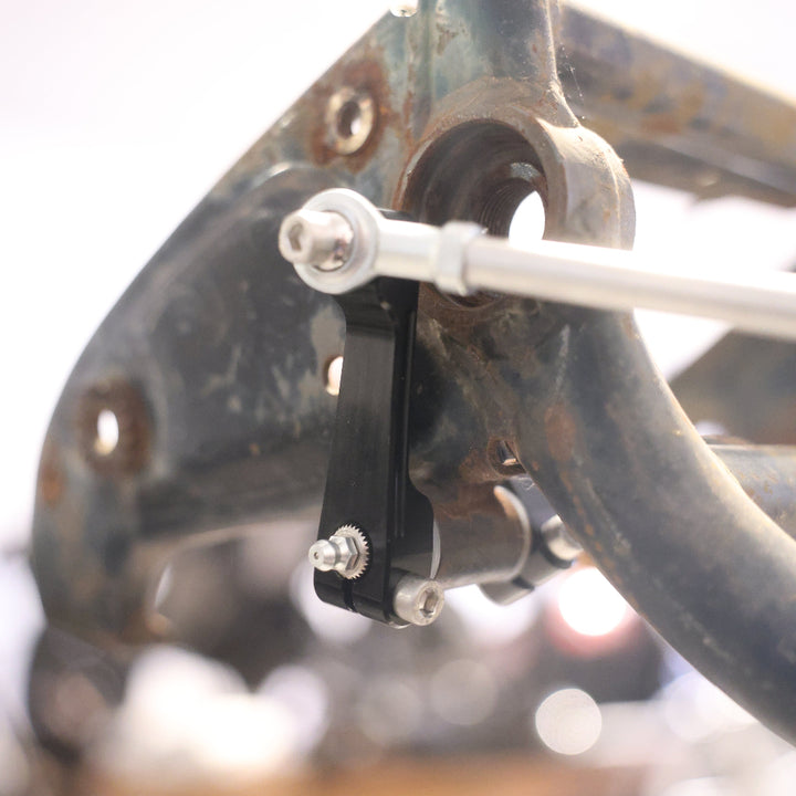 Close-up of a mechanical component on a vehicle, possibly a motorcycle or atv, with blurred background.